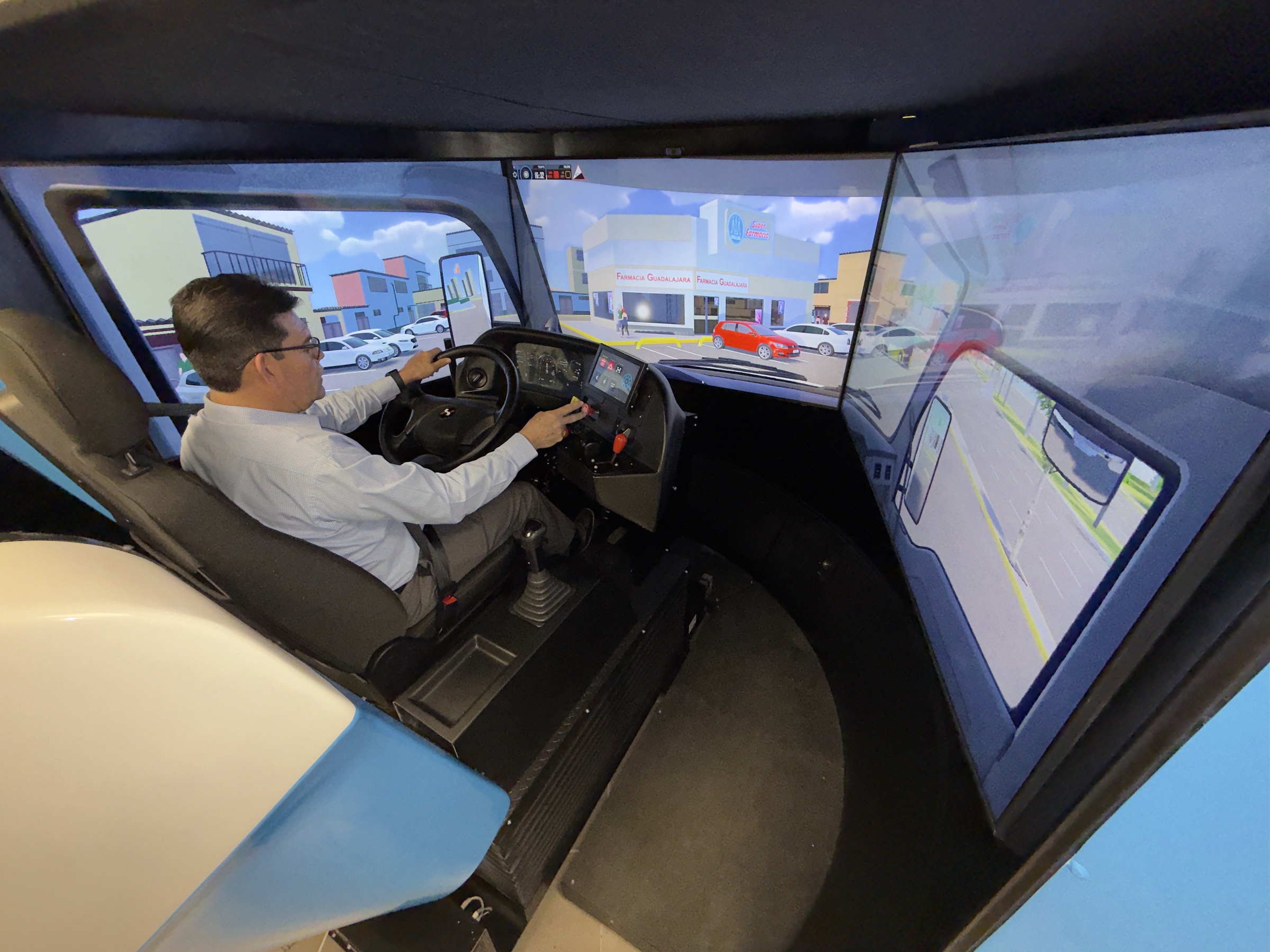 Operador conduciendo el simulador APEX con una sucursal de Farmacia Guadalajara modelada en el escenario virtual